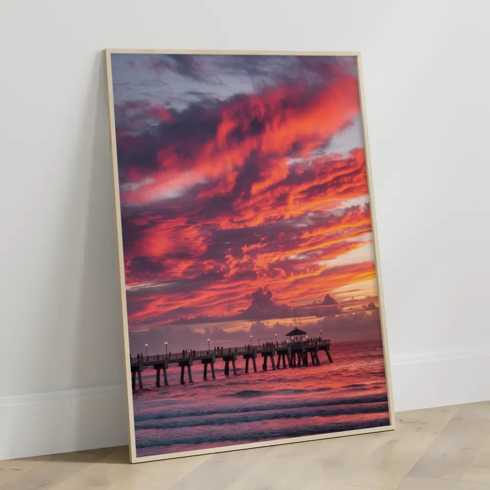 Poster traumhafter Sonnenuntergang am Strand mit Pier und Wolkenkunst