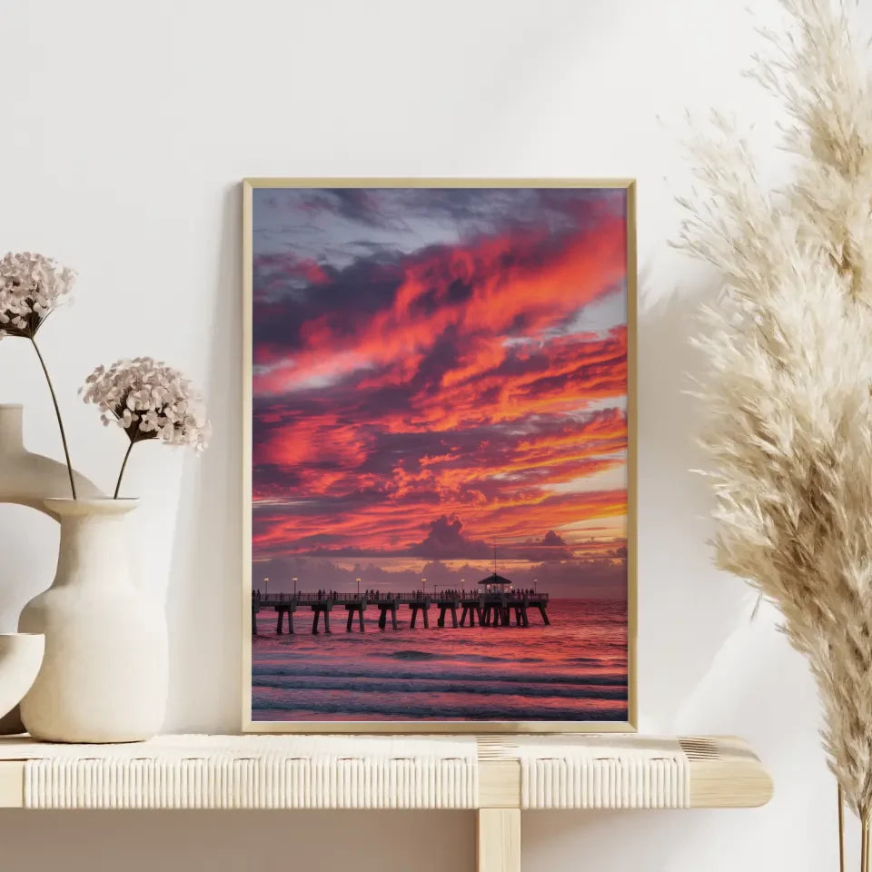 Poster traumhafter Sonnenuntergang am Strand mit Pier und Wolkenkunst