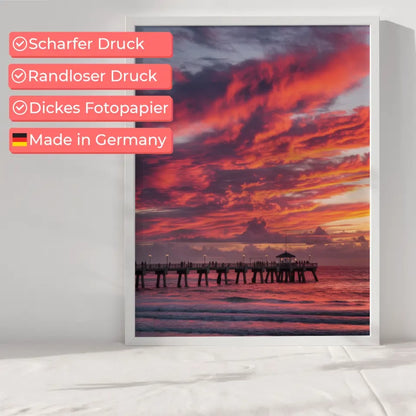 Poster traumhafter Sonnenuntergang am Strand mit Pier und Wolkenkunst