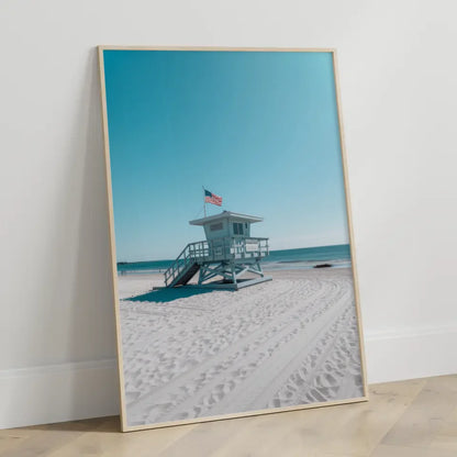 Ruhiger Strand Poster mit Rettungsschwimmerturm und blauem Himmel