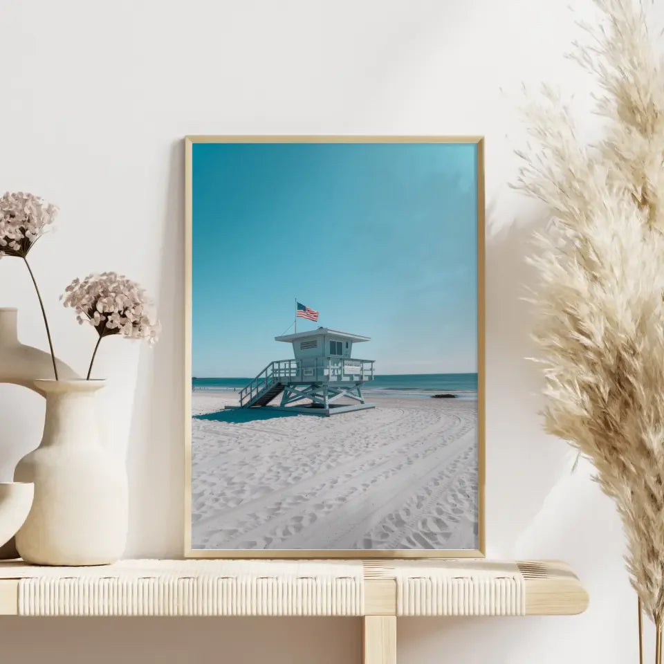 Ruhiger Strand Poster mit Rettungsschwimmerturm und blauem Himmel