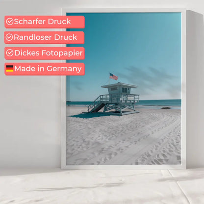 Ruhiger Strand Poster mit Rettungsschwimmerturm und blauem Himmel