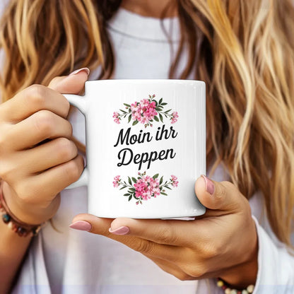 Lustige Tasse mit Spruch Moin ihr Deppen und Blumenarrangement