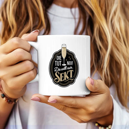 Lustige Tasse mit Abzeichen und Spruch die tut nix Sekt